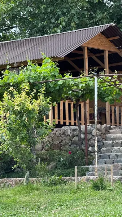 Covered wooden veranda above a stone wall