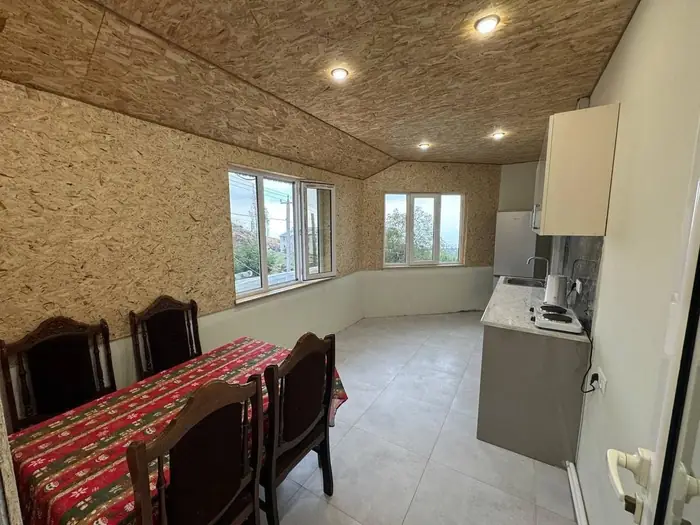 Dining table with six chairs beside windows looking onto the valley