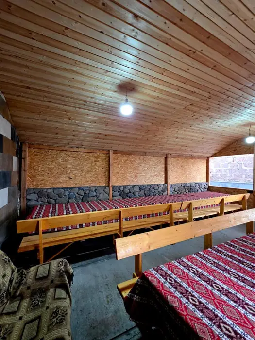 Long wooden benches on both sides of the tables under a pine ceiling