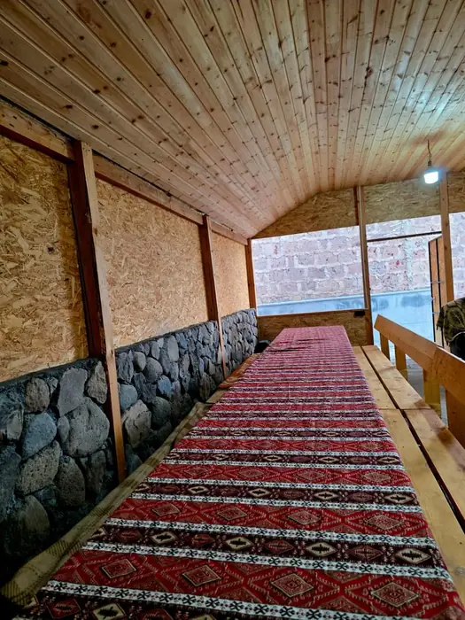 A table running the length of the room, laid with patterned carpet cloth