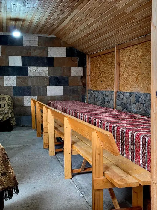 Long table against a chequered tuff stone wall