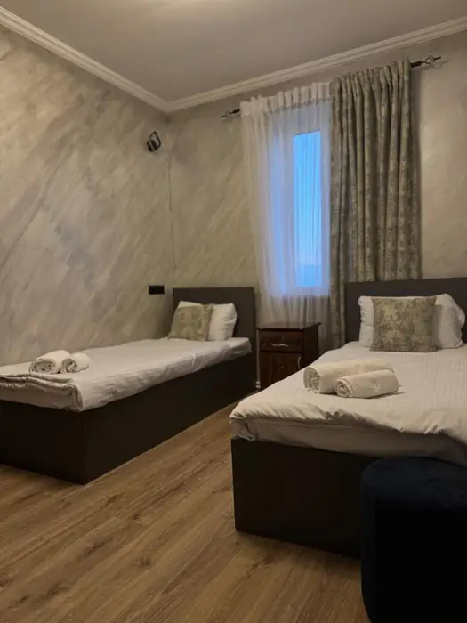 Twin room with two separate beds and a carved bedside table