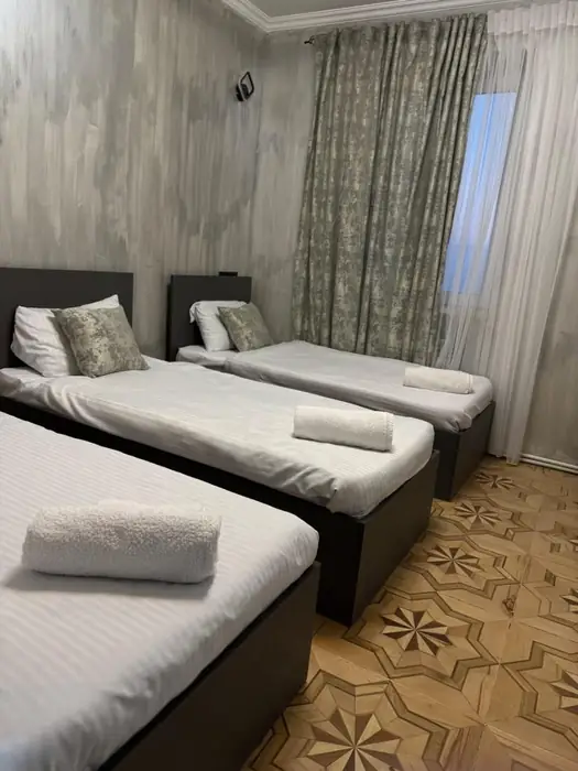 Room with three single beds on inlaid star parquet